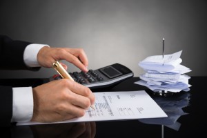 Hände eines Geschäftsmannes beim Bearbeiten von Rechnungen