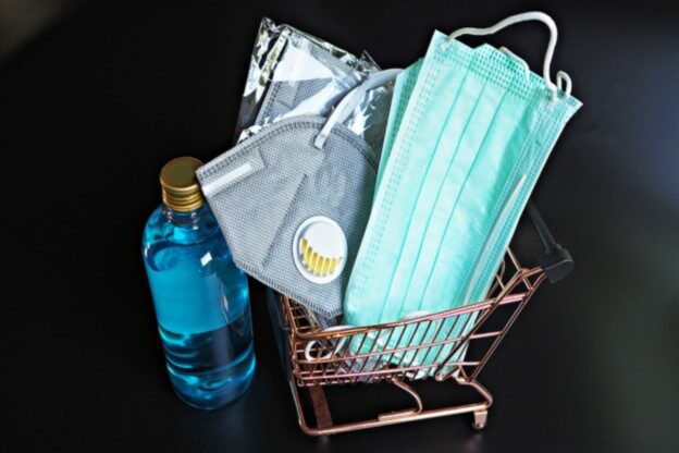 Mundschutz-Maske, Desinfektionsmittel und weitere Hygieneartikel liegen im Einkaufswagen